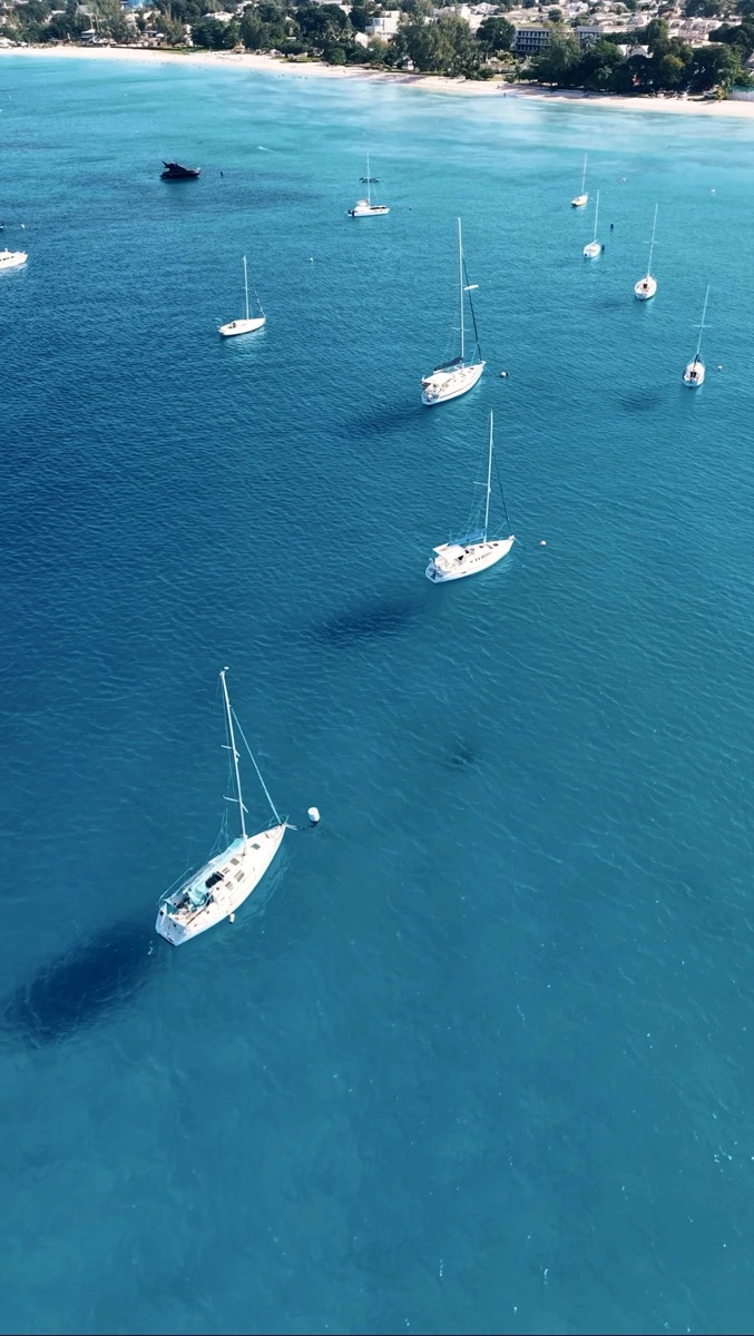 Boats anchored in turquoise water, aerial